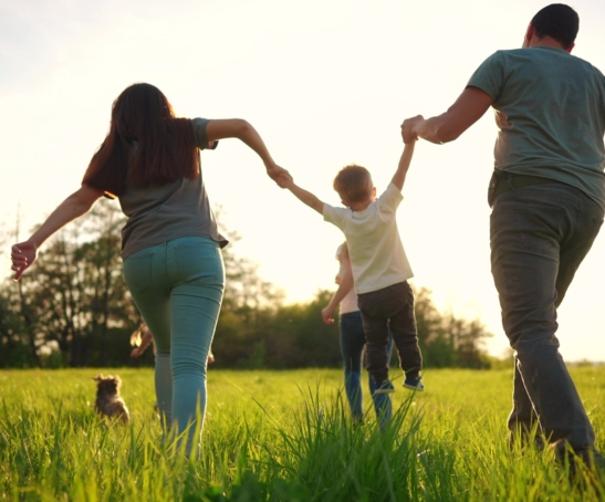 happy family running in park in summer. mom and dad hold their son by the hands run throw up in the forest park on the grass in the summer. happy family kid dream concept lifestyle